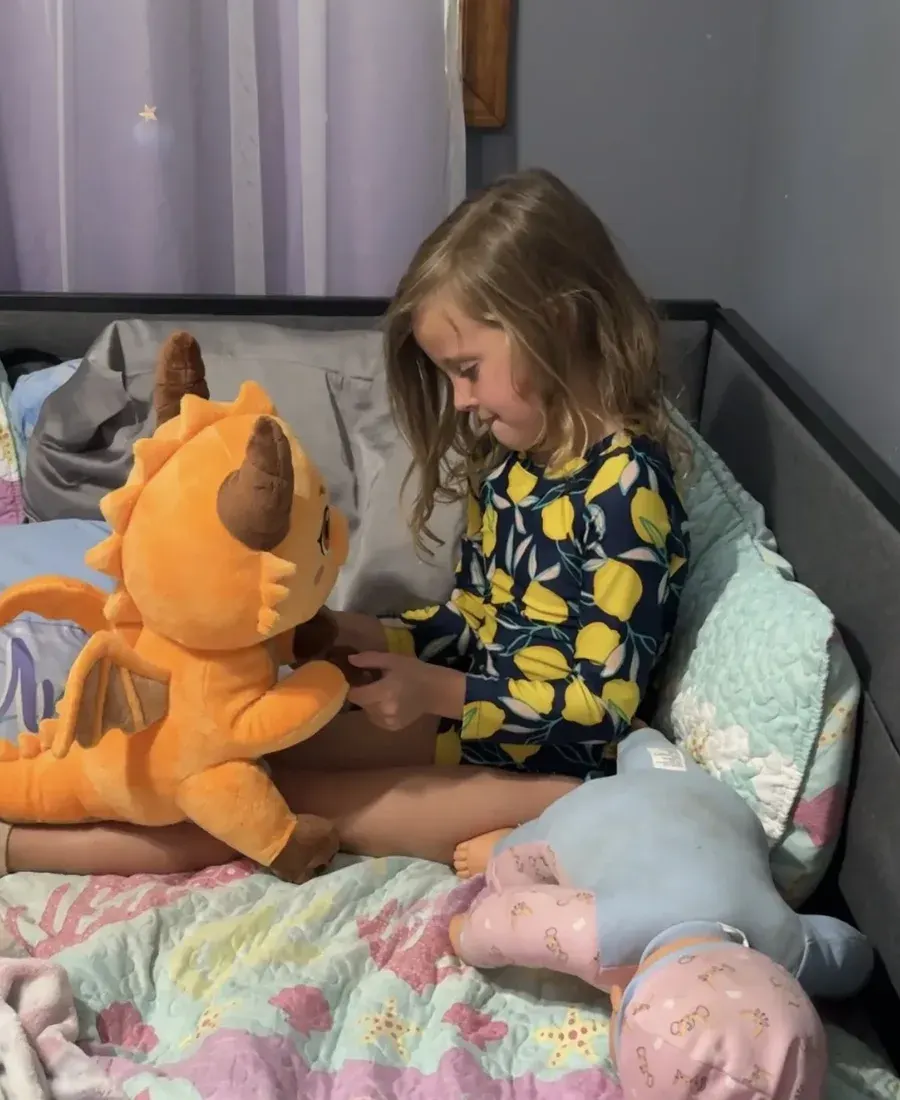 A girl sitting on her bed playing with Ash